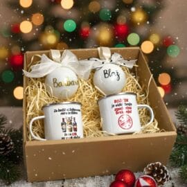 Božični darilni paket za par z 2 emajliranima lončkoma (Gin in Perverznež) in 2 personaliziranima okraskoma z imenoma Barbara in Blaž, na zasneženem božičnem ozadju.