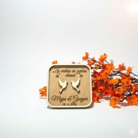 Personalizirana darila za svate – kvadraten lesen poročni magnet z vgraviranim verzom "Za vedno se začne danes", motivom dveh belih golobčkov ter imenoma Maja in Gregor na beli podlagi z oranžnim cvetjem