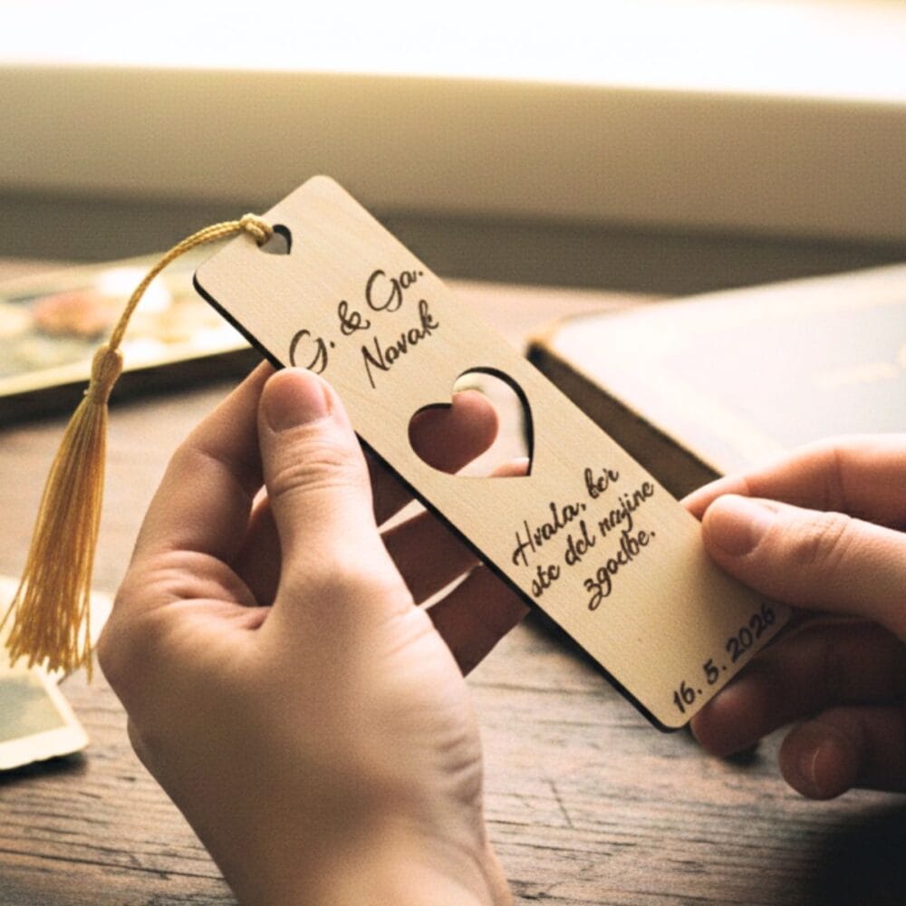 Roke držijo personalizirano leseno knjižno kazalo z vgraviranim napisom G. & Ga. Novak in zlato resico, v ozadju pa so zamegljene stare fotografije in knjige, kar ustvarja nostalgičen videz poročne zahvale.
