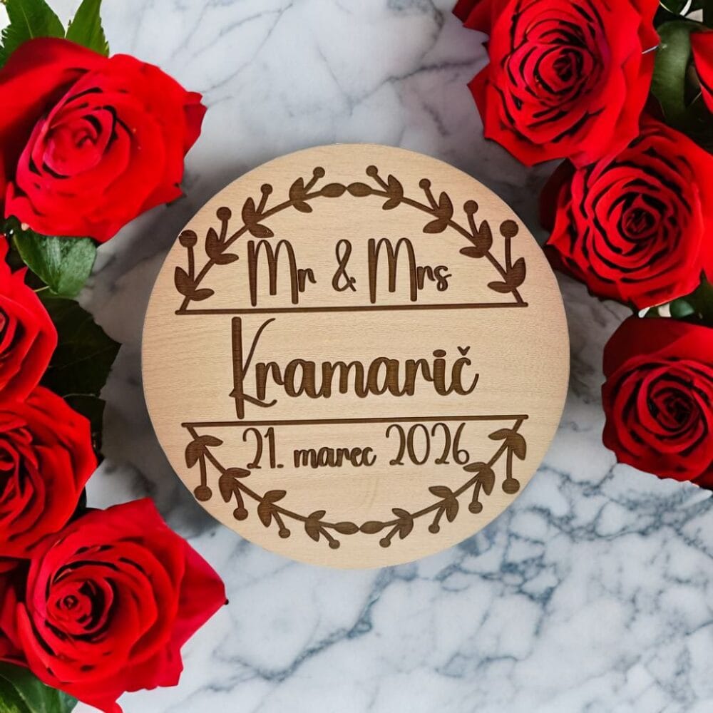 Personaliziran leseni poročni magnet z gravuro Mr & Mrs Kramarič, obdan z bogatimi rdečimi vrtnicami na beli marmorni podlagi, primeren kot elegantna poročna zahvala ali darilo za svate.