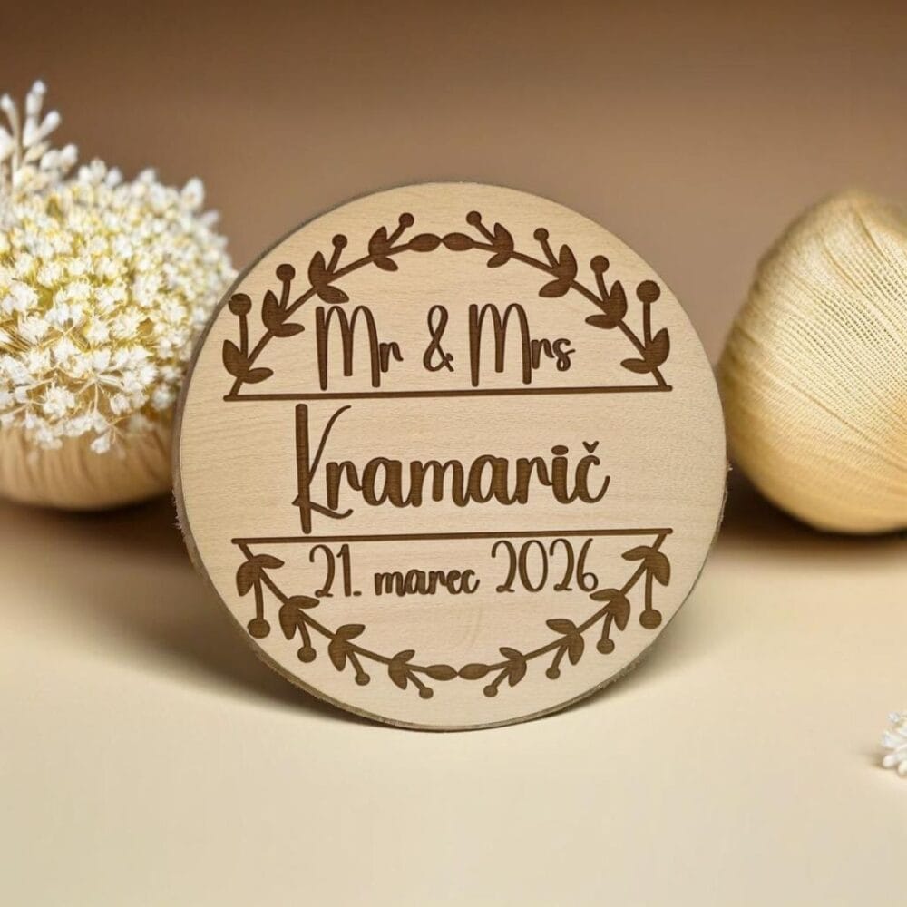 Personaliziran leseni poročni magnet okrogle oblike z gravuro napisa Mr & Mrs Kramarič in datumom, obdan z venčkom, kot unikatno darilo za svate in poročna zahvala.