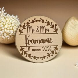 Personaliziran leseni poročni magnet okrogle oblike z gravuro napisa Mr & Mrs Kramarič in datumom, obdan z venčkom, kot unikatno darilo za svate in poročna zahvala.