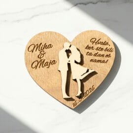 Personaliziran lesen poročni magnet v obliki srca z vgravirano silhueto para, imenoma Miha in Maja ter zahvalo, postavljen na belo marmorno podlago z elegantno senco.