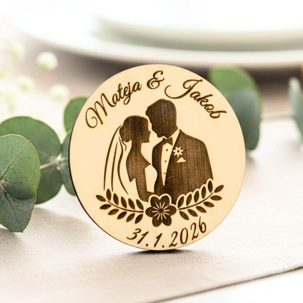 Detajl lesenega poročnega naprsnika z nežno gravuro cvetličnega venca in silhueto para, ki služi kot trajen spomin za svate.