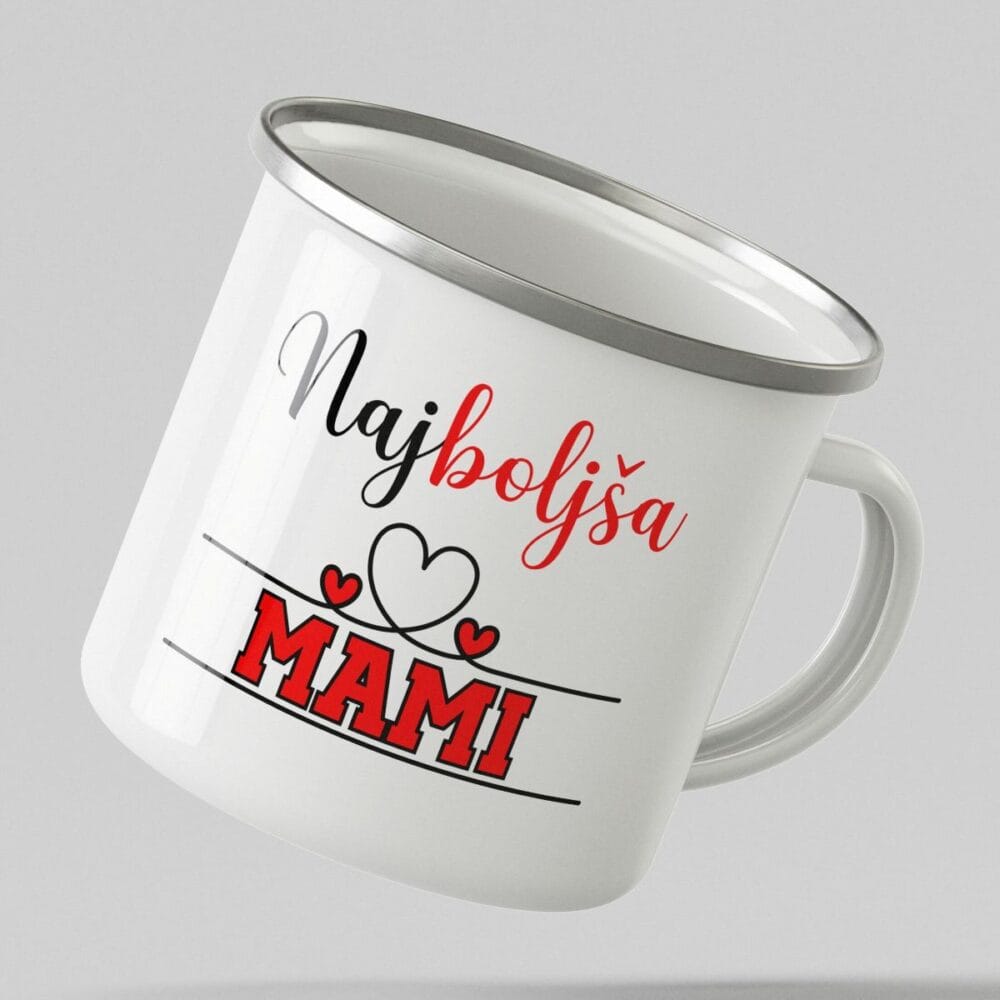 Bela emajlirana skodelica s srebrnim robom in napisom 'Najboljša MAMI', ki lebdi v zraku na nevtralnem sivem ozadju.
