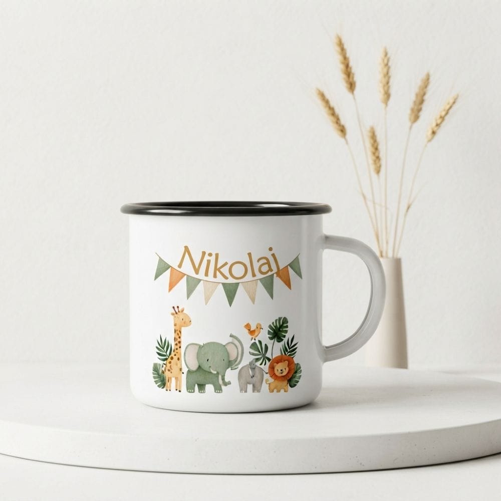 Beli emajlirani lonček s črnim robom in personaliziranim napisom "Nikolaj" pod nizom barvnih trikotnih zastavic. Na sredini lončka je risana ilustracija safari živali: žirafa, velik slon, majhen slon, ptica in lev, obdani z zelenim listjem. Lonček stoji na belem podstavku v svetlem prostoru, v ozadju pa je vaza s suhimi klasjem.